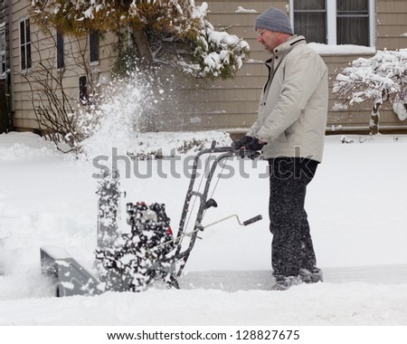 Man using snow-blower after winter storm