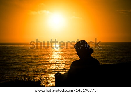 Silhouetted person at sunset on beach