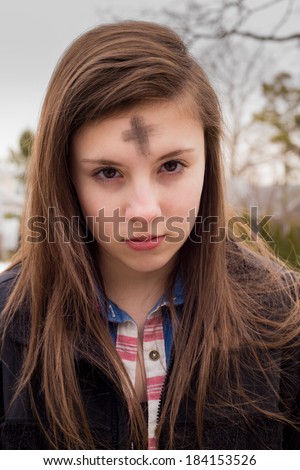 Teenage girl with cross on forehead in observance of Ash Wednesday