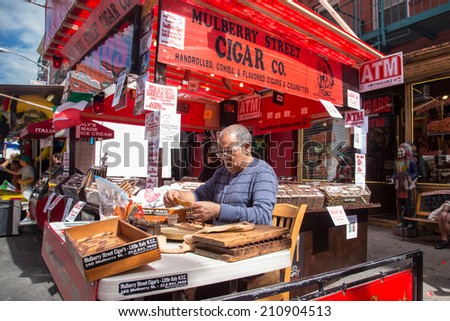 NEW YORK CITY - SEPT 13, 2013:: Hand rolling cigar vendor at 87th Feast of San Gennaro in NYC.  This annual feast celebrates Italian heritage on the streets of Little Italy.