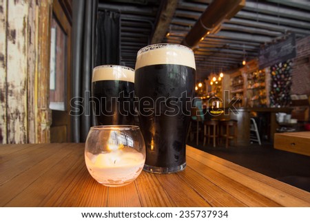 Dark beer and candle in pub setting