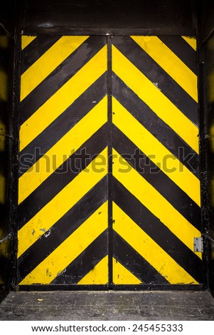 Black and yellow caution stripes on industrial door