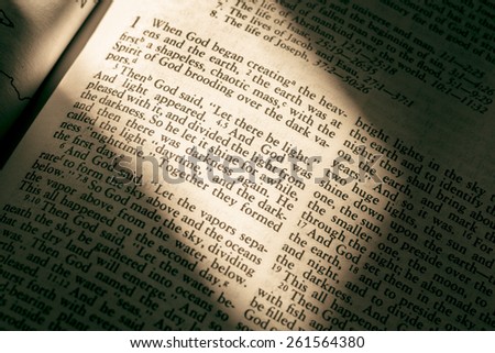 Holy Bible with light casting on Genesis