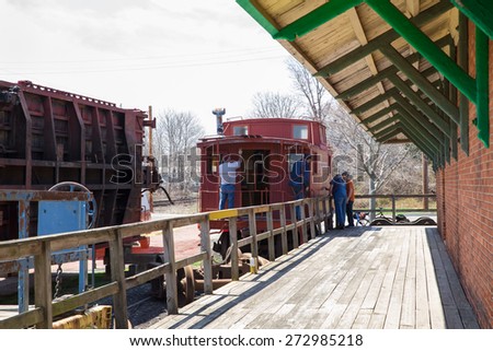 GREENPORT, LONG ISLAND, NY - APRIL 18, 2015:  Workers restoring old Long Island Railroad train at The Railroad Museum of Long Island in Greenport NY.