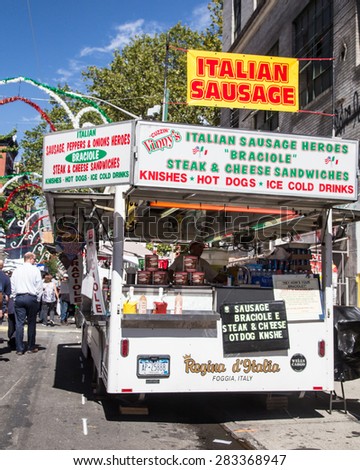 NEW YORK CITY - SEPTEMBER 13, 2013:  View of street vendor food cart with people visible at the Feast of San Gennaro in Little Italy in Manhattan.