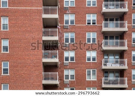 Typical apartment building exterior with brick, windows and balconies