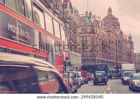 LONDON, UNITED KINGDOM - OCTOBER 8, 2014:  Vintage style street view of London along busy Brompton Road in London with Harrods and iconic double decker bus.