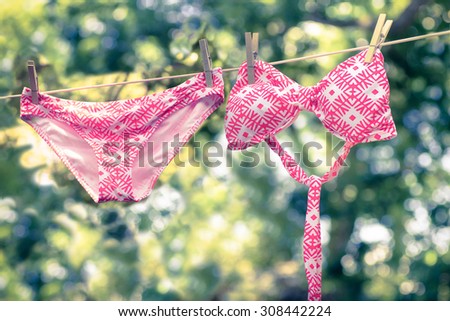 Retro tone image of cute bikini bathing suit hanging on a line to dry