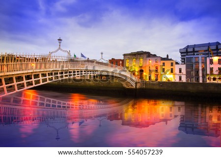 Ha\'penny Bridge of the River Liffey in Dublin Ireland in the evening with lights and reflections