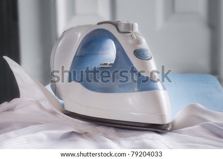 A household iron on a wrinkled shirt