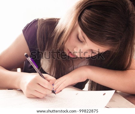 Teenage girl doing homework for school.  This is image is high key.