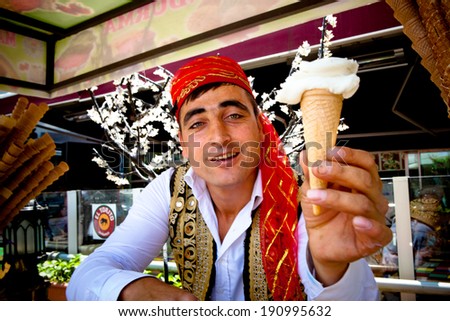 ISTANBUL - MAY 17 - Popular Turkish ice-cream vendor hands over a cone of ice-cream after performing playful tricks on May 17, 2011 in Istanbul.
