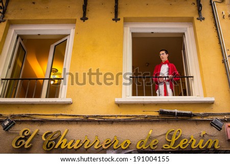 PAMPLONA - JUL 10: Boy watches San Fermin running of the bulls festival from his window on July 10, 2013 in Pamplona, Spain.