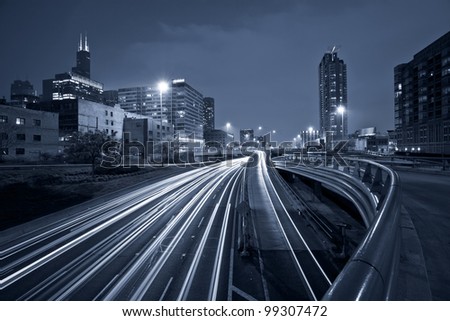 Nighttime highway traffic. Toned image of multi lane highway in Chicago downtown.