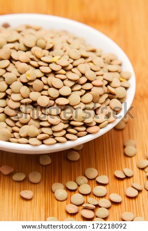 Lentils in white bowl on wooden tabletop