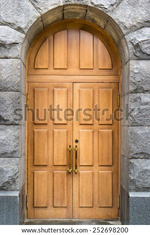 Massive wooden double door with stone arch