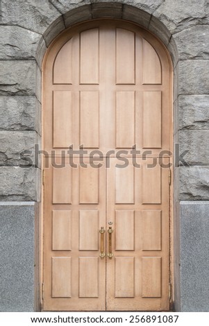 Massive wooden double door with stone arch