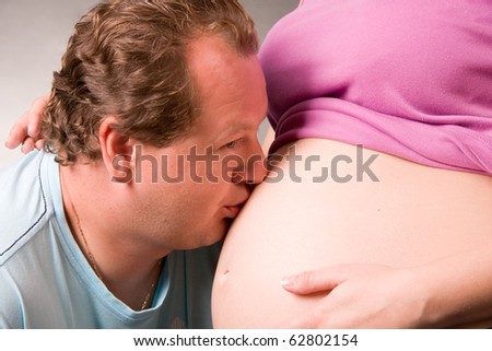 man kisses the pregnant wife in a belly