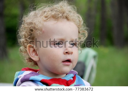 Portrait of little year-old curly girl with interest looking after