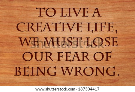 To live a creative life, we must lose our fear of being wrong - quote by unknown author on wooden red oak background
