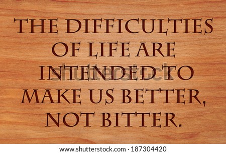 The difficulties of life are intended to make us better, not bitter - quote by unknown author on wooden red oak background