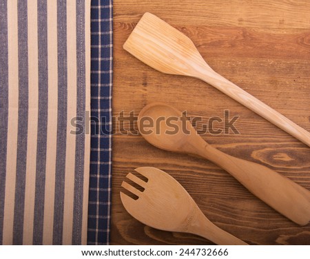 Classic kitchen towels and wooden utensils on dark wood tabletop