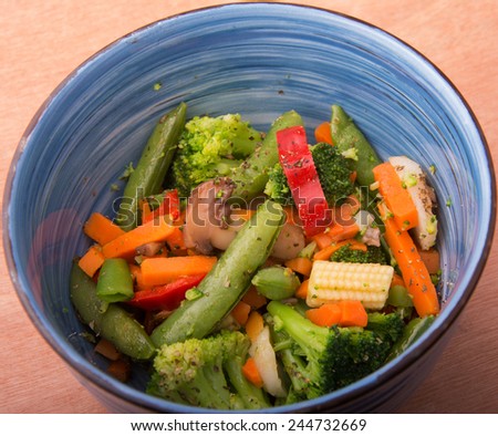 Colorful steamed vegetables in a blue bowl