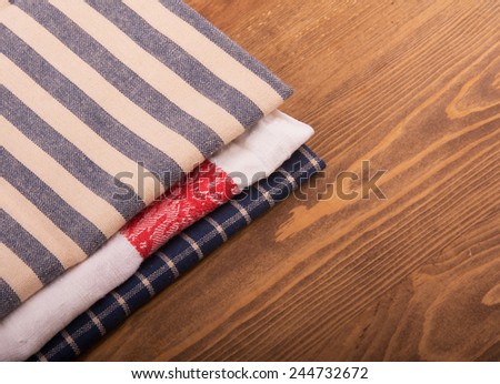 Old linen kitchen towels folded on dark wooden table