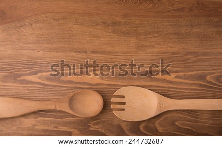 Wooden utensils on dark wood tabletop, with copy space