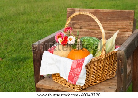 Harvest basket with produce and flowers on a rustic chair