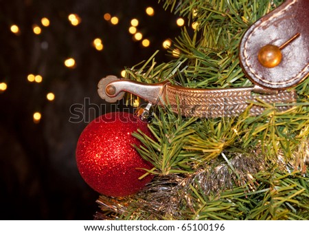 Cowboy Christmas - spur with a red ball ornament, decorating the tree