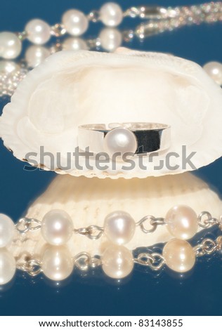 Silver ring with a single pearl inside a seashell