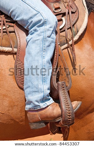 Rider\'s foot in stirrup in a western saddle