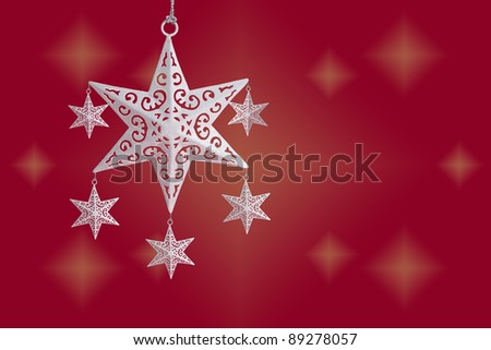 White Christmas star ornament on red starry background, with copy space