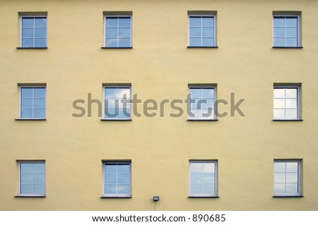 Plain elevation with windows reflecting the sky.