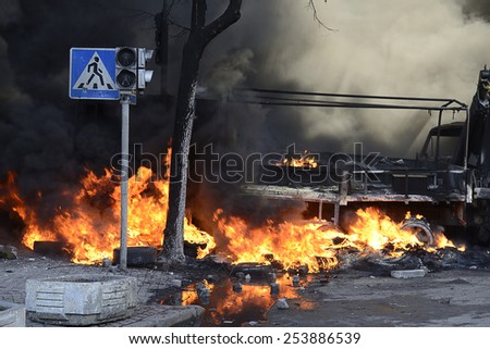 KIEV UKRAINE-FEBRUARY 18, 2014:  Fire protecting by defend oneself protesters of  armed forces attack at first day of mass shooting in Kyiv at Euromaydan time. Ablaze cars on the street.