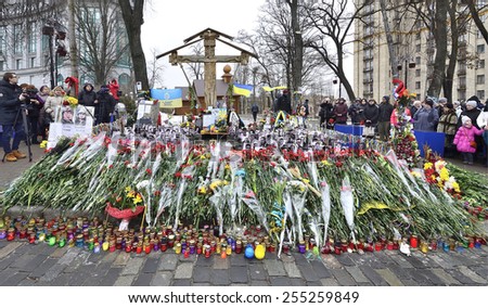 KIEV UKRAINE -FEBRUARY 22, 2015: Anniversary of mass shooting the armless  Euromaidan demonstrators by armed special forces. Memorial Gallery under Cross, peoples and flowers