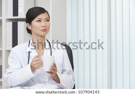A Chinese Asian female medical doctor drinking tea or coffee in a hospital office