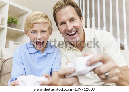 Happy family, man and boy, father, son, having fun playing video console games together.