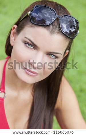 Portrait of a beautiful brunette young woman with stunning green eyes, shot outside in natural light