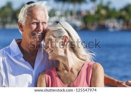 Happy romantic senior man and woman romantic couple together embracing by tropical sea or river