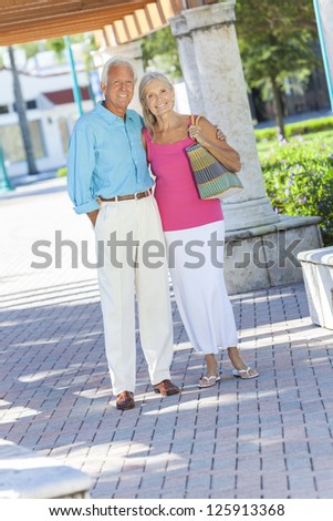Happy senior man and woman couple walking together outside in sunshine