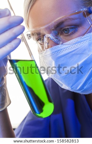 A female medical or scientific researcher or doctor looking at a green solution in a laboratory
