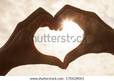 Hand Heart Shape Silhouette Made Against The Sun &Amp; Sky Of A Sunrise Or Sunset