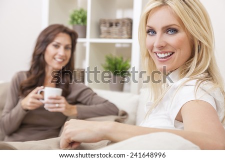 Two beautiful women friends at home drinking tea or coffee together