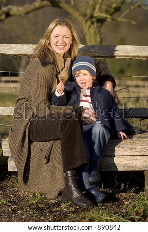 A young son asks his mother a question while out in the countryside.