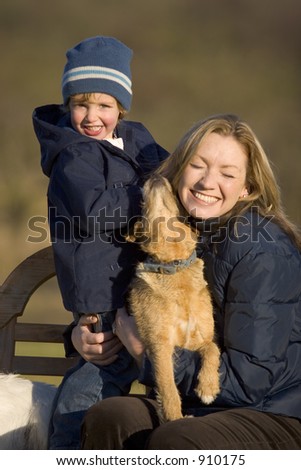 A mother her young son and the family dog out in an English country garden