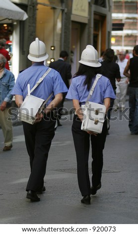 Two Italian Police officers, one man, one woman, walk through the streets of Florence, Italy