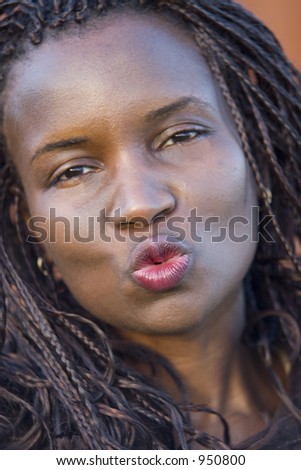 A beautiful young black woman blowing a kiss to the camera