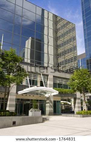 Entrance to a glass fronted office with reflections of surrounding buildings in the windows.